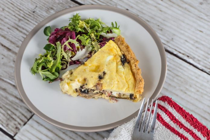 Slice of quiche with a side salad