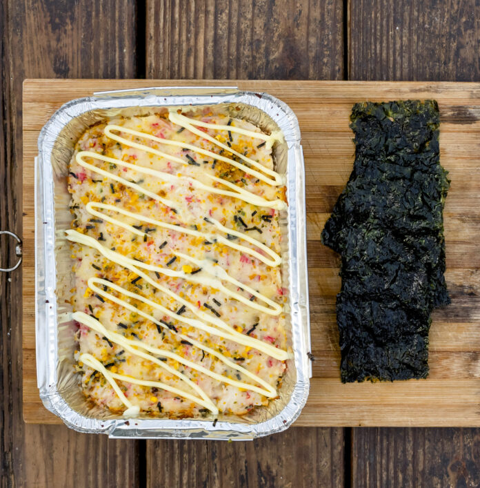 Top view of Baked Sushi served with Nori Seaweed on a wooden tray.